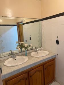 a bathroom with two sinks and a mirror at Villa nuira in Inezgane