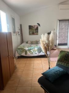 a room with a bed and a couch and a floor at Petit Paradis in Besse-sur-Issole