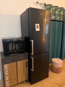 a black refrigerator and a microwave next to a table at Petit Paradis in Besse-sur-Issole