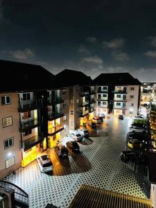 a parking lot with cars parked in front of a building at 2 Chambres Élégantes Confort Moderne in Santeo