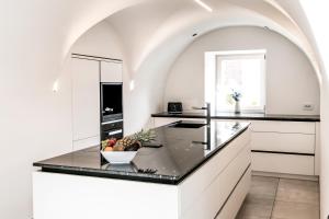 a kitchen with a counter with a bowl of fruit on it at Stylish Alpine Apartment with Terrace, Fireplace & Mountain View near Sterzing - Villa Tribulaunblick in Colle Isarco