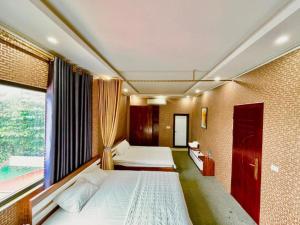 a bedroom with two beds and a large window at Cô Chung Hotel in Lao Cai