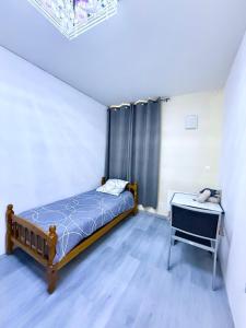 a bedroom with a bed and a table in a room at Face à la gare - Chambre 3 in Roanne