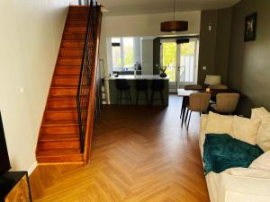 a living room with a staircase leading to a living room at Maison rénové - Centre Cambrai in Cambrai
