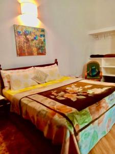 a bedroom with a bed with a quilt on it at Sana Villa & Resort Anjuna Beach Goa in Anjuna