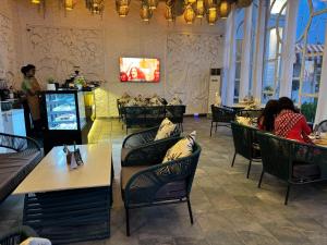 a restaurant with chairs and tables and a tv at Torque Stays in Noida