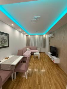 a living room with a couch and a table and a tv at Nela Bl in Banja Luka