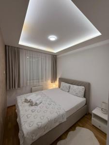 a bedroom with a large white bed with a white ceiling at Nela Bl in Banja Luka