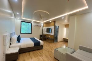 ラクナウにあるMangalam Innのベッドとソファのあるホテルの部屋 +12枚の写真