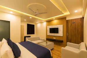 a hotel room with a bed and a tv at Mangalam Inn in Lucknow