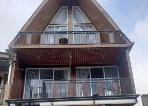 a tall building with windows and a balcony at Villa Castanea Dieng in Diyeng +2 photos