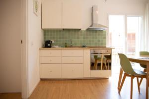 a kitchen with white cabinets and a table at Solemar Sicilia - Casa Minerva in Santa Flavia