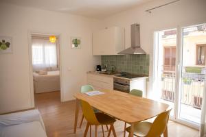 a kitchen with a wooden table and chairs in it at Solemar Sicilia - Casa Minerva in Santa Flavia