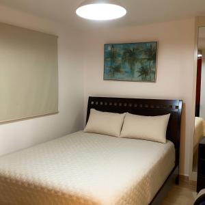 une chambre avec un lit avec un couvre-lit blanc dans l'établissement Beachfront Apartment Marbella, Juandolio, à Villas del Mar 9 autres photos