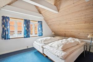 a bed in a room with a wooden ceiling at Stort byhus i centrum af Skagen in Skagen