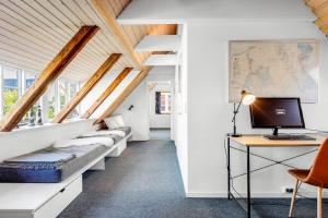 a room with white walls and a desk with a computer at Stort byhus i centrum af Skagen in Skagen