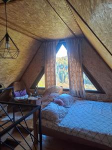 a bed in a room with a large window at Pogled na Romaniju in Pale