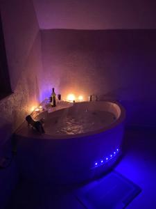 a dark bathroom with a tub with lights in it at Pogled na Romaniju in Pale +25 photos