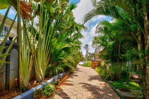 uma passarela de tijolos com palmeiras na lateral de uma casa em Rofinos Cottages em Parra