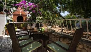 un patio con mesa y sillas y una casa para perros en Apartment Zelja, en Orebić