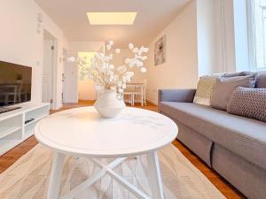a living room with a white table and a couch at 58b Thorpe Road - City Centre in Norwich
