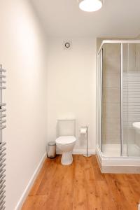 a white bathroom with a toilet and a shower at 58b Thorpe Road - City Centre in Norwich