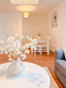 a white vase with white flowers on a table in a living room at 58b Thorpe Road - City Centre in Norwich +4 photos