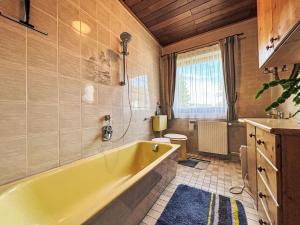 a bathroom with a yellow tub and a toilet at Apartment Ferienwohnung Monika by Interhome in Öblarn +27 photos