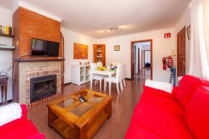 un salon avec un canapé rouge et une cheminée dans l'établissement Es Pins, à Font de Sa Cala