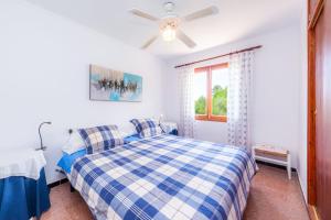 - une chambre avec un lit à damiers bleu et blanc dans l'établissement Es Pins, à Font de Sa Cala 59 autres photos