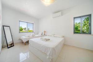 a white bedroom with two beds and a mirror at Casa ELI - 3 Bedroom house with pool - HolidaysPT in Quelfes