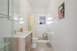 a white bathroom with a toilet and a sink at Casa ELI - 3 Bedroom house with pool - HolidaysPT in Quelfes