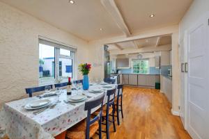 a dining room with a table and chairs and a kitchen at Finest Retreats - The Breakers in Poughill
