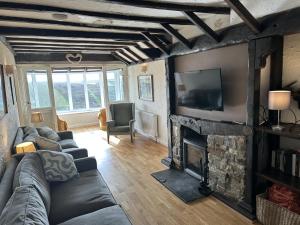 a living room with a couch and a fireplace at Finest Retreats - The Breakers in Poughill