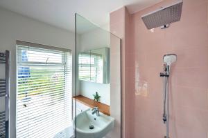a pink bathroom with a sink and a shower at Finest Retreats - The Breakers in Poughill +25 photos