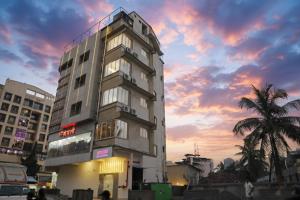 a tall building with a sunset in the background at Atithi Deluxe Rooms in Nale Sopāra