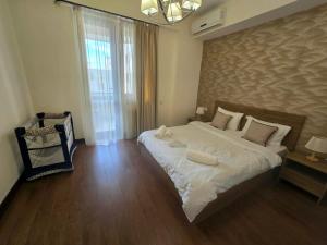 a bedroom with a large bed with white sheets at Your Yerevan Home in Yerevan