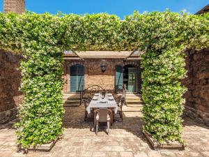 ein Torbogen mit einem Tisch und Stühlen darunter in der Unterkunft Holiday Home Casale Di Befania by Interhome in Vetralla