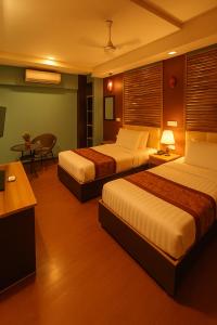 a hotel room with two beds and a table at Rara HM in Male City