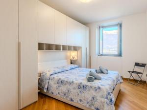 a bedroom with a bed and a chair and a window at Apartment Blue Lake by Interhome in Bellano