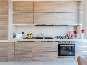 a kitchen with wooden cabinets and a stove at Apartment Blue Lake by Interhome in Bellano