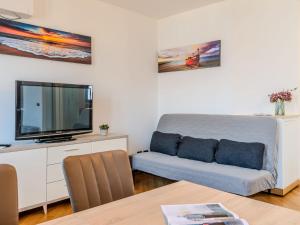 a living room with a couch and a flat screen tv at Apartment Blue Lake by Interhome in Bellano