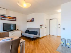 a living room with a couch and a tv at Apartment Blue Lake by Interhome in Bellano