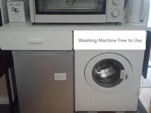 a microwave sitting on top of a washing machine at Marine Guest House in Eastbourne