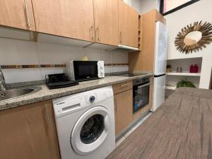 a kitchen with a washing machine and a microwave at Atuaire Home Mirador de Saldaña en pleno centro Historico in Burgos