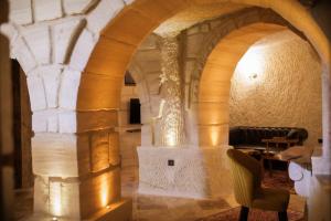 a stone archway in a room with a chair at Rose Moon Cave in Macun Çiftliği +92 photos