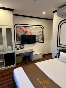 a bedroom with a bed and a tv on a wall at Golden Hotel in Hanoi
