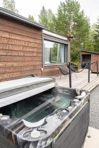 a hot tub on a deck next to a house at Himosranta Suite A - Private Suite with Hot Tub & Lake Views in Jämsä