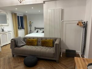 a living room with a couch in front of a bed at The Old Stable in Cottingham