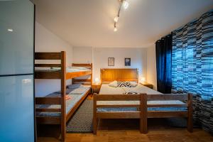 Un dormitorio con tres literas y un frigorífico. en Flex SelfCheckIns 180 - Zagreb - 1 Bedroom - Parking - Loggia, en Zagreb